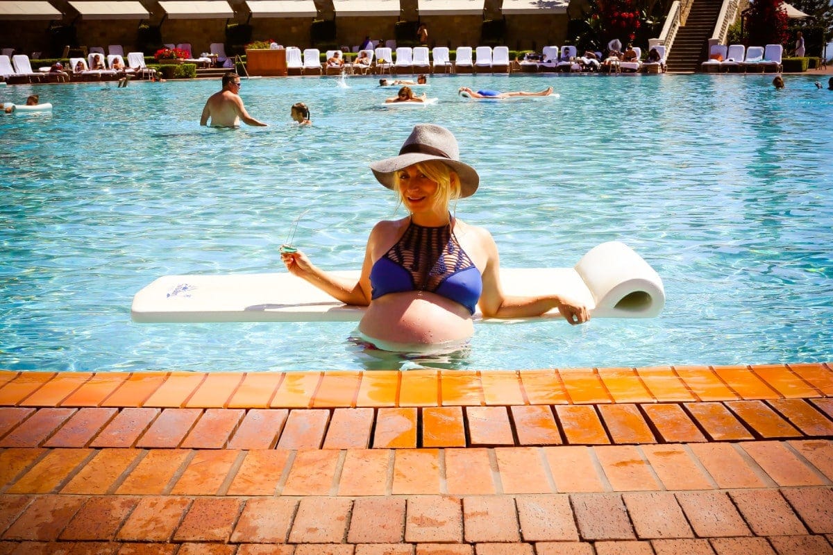 What is a babymoon pregnant woman in a pool at a resort on her babymoon