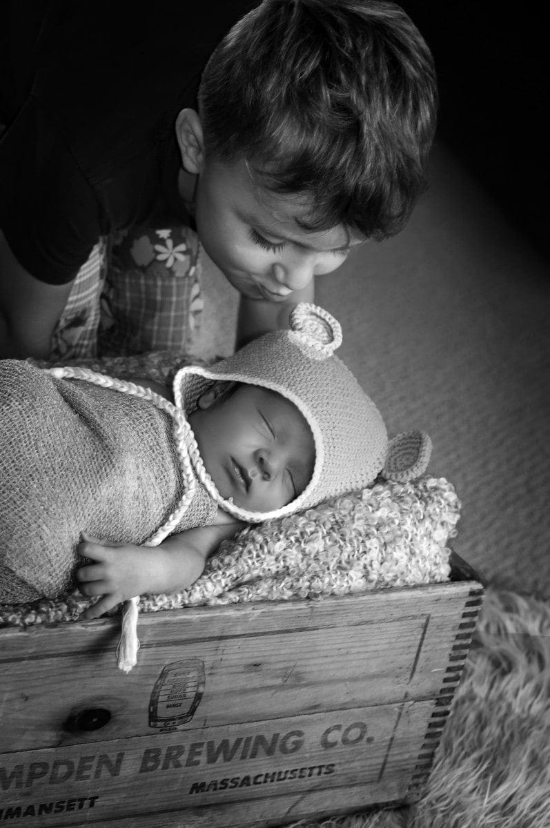 brother kissing sleeping baby