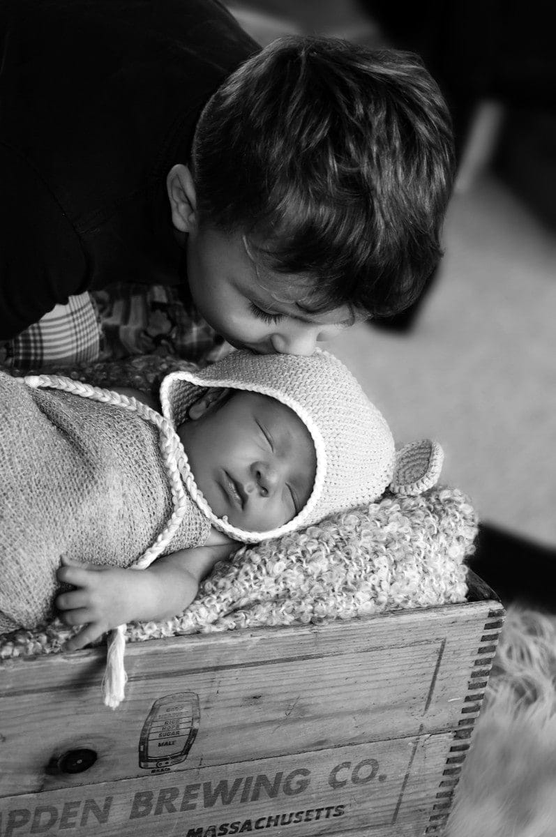 brother kissing baby sleeping