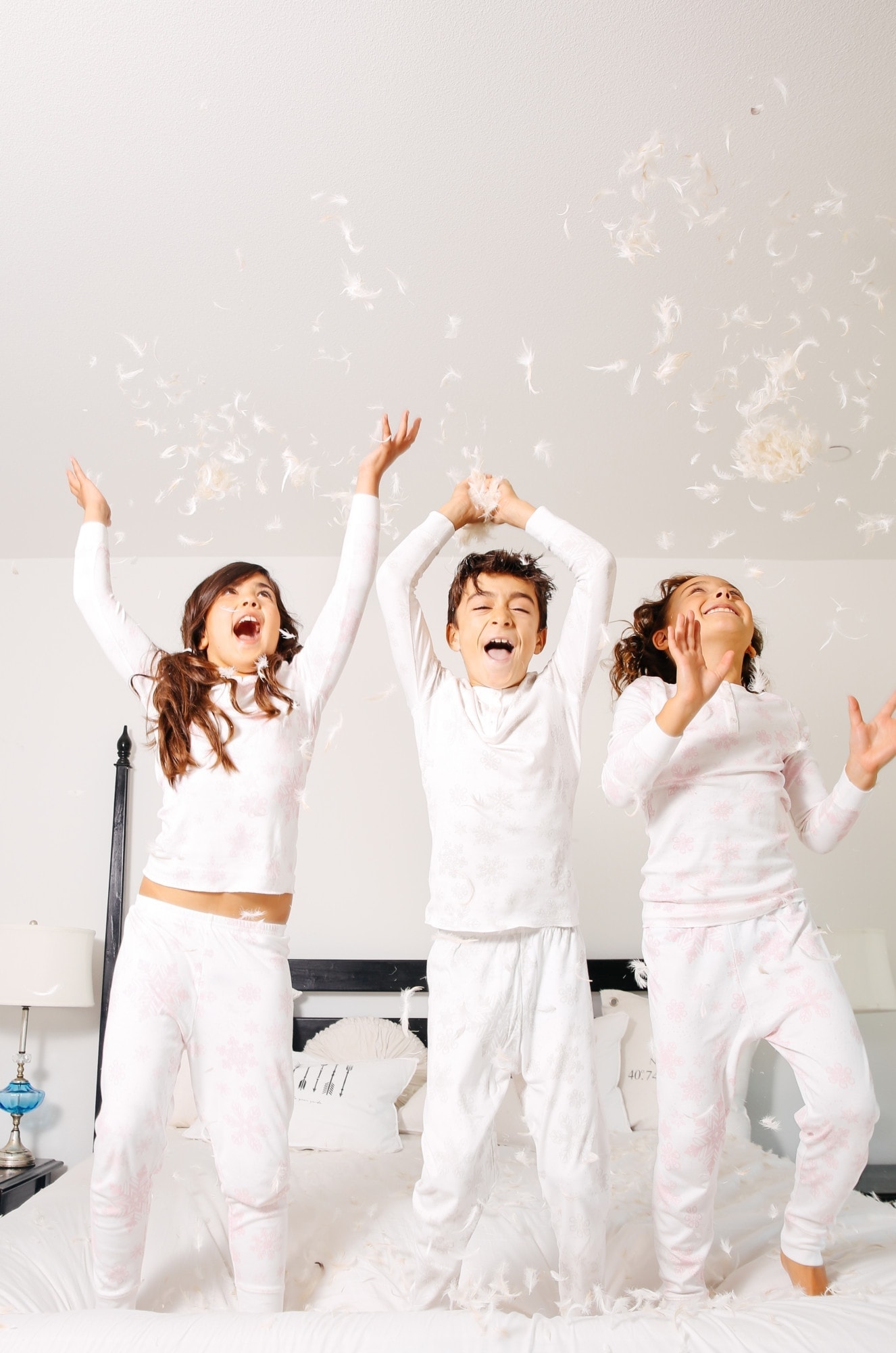 kids jumping on bed with feathers