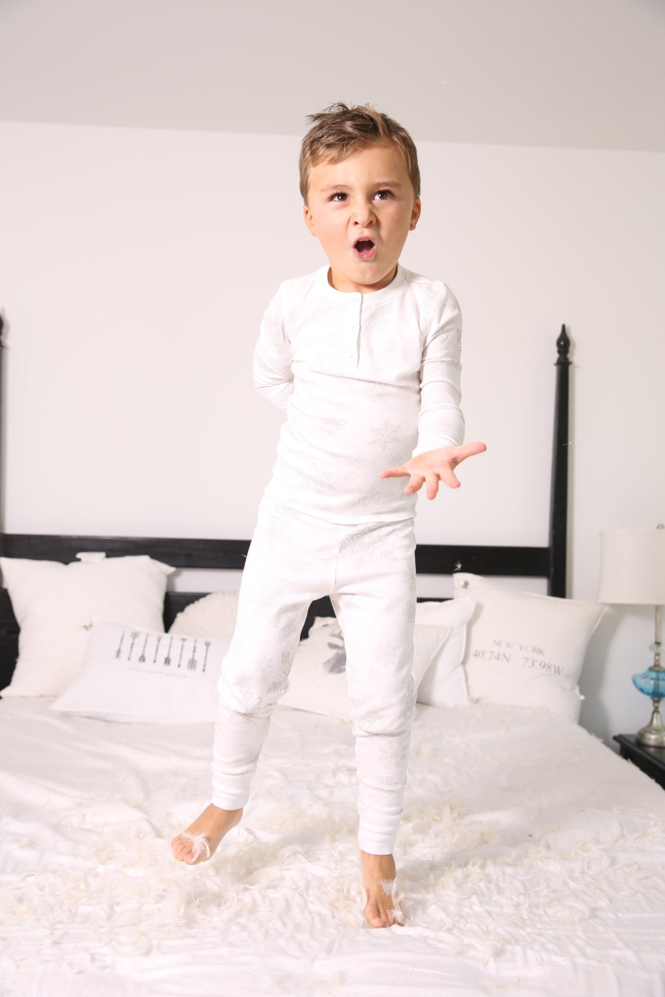 boy jumping on bed