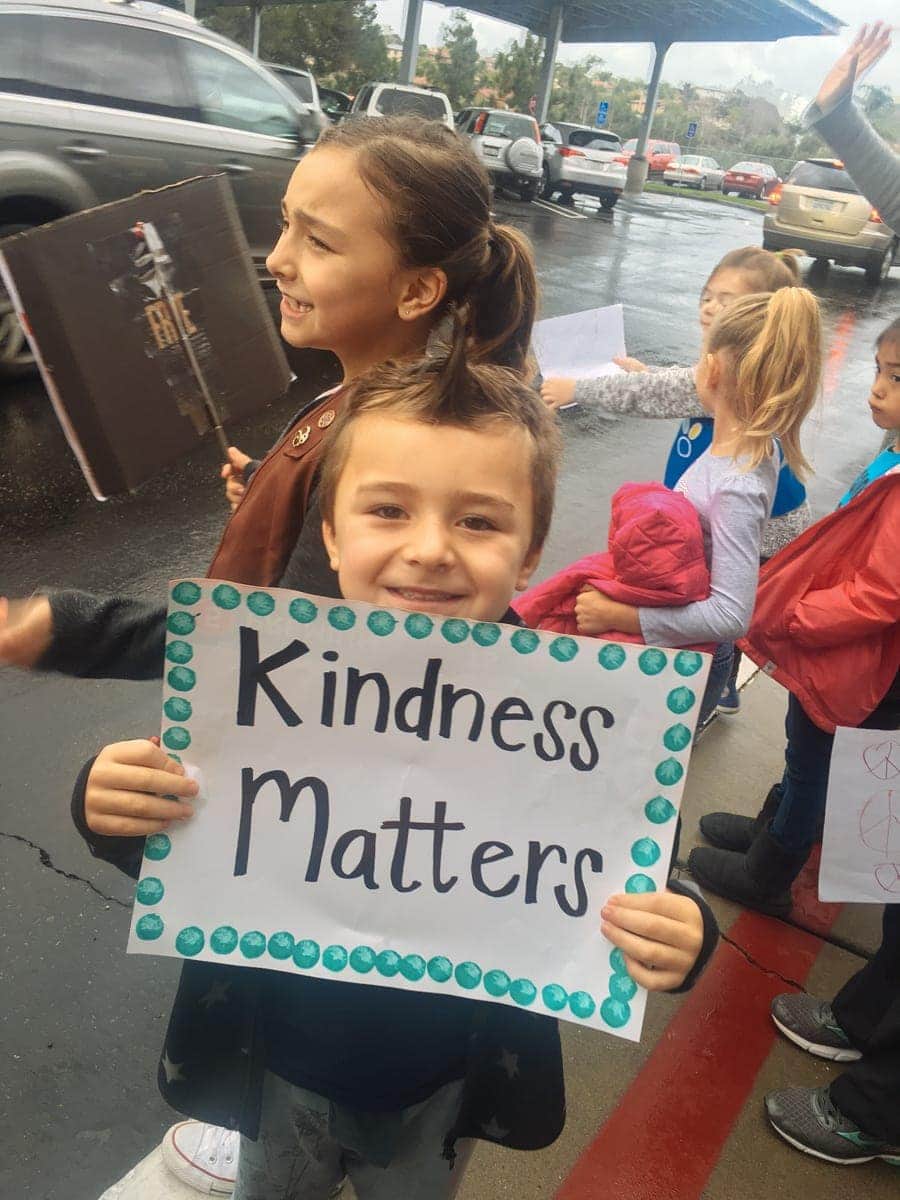 boy holding kindness matters sign