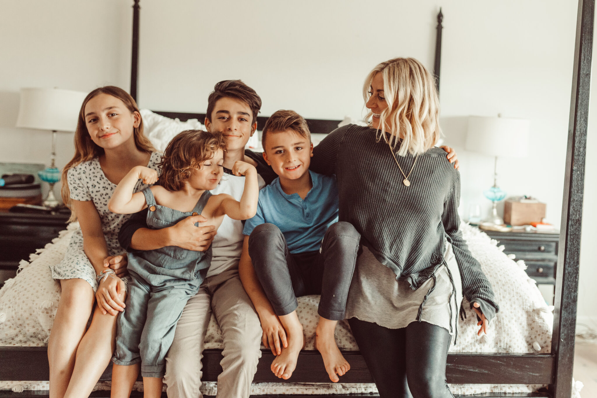 mom and kids sitting on bed