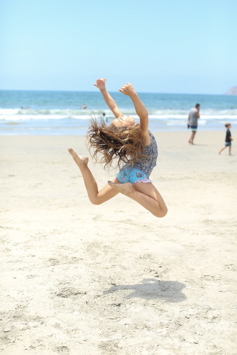 child jumping on the beach