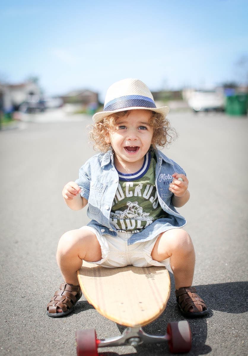 toddler on skateboard with hat