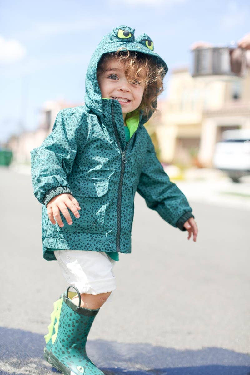 happy boy in raincoat and rain boots