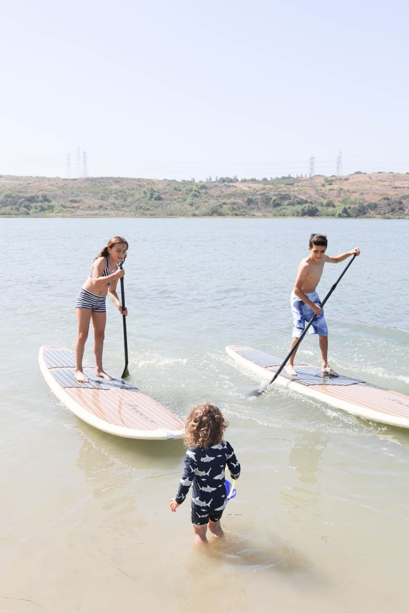 Kids Standing Up on Paddle Boards #familytravelsandiego #sandiego #fourseasonsresidenceclub #bigfamilytravel 