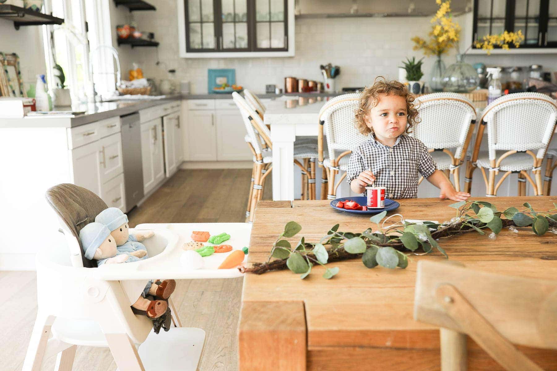 Kid Eating Together with Baby Dolls