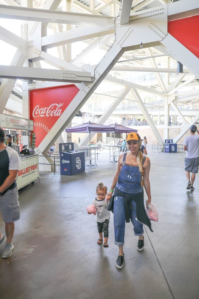 Mom holding her child's hand while walking inside the Stadium #familyday #weekend #familydaysout #citygirlgonemom #momandchild