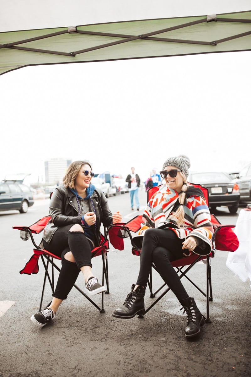 two girls sitting at tailgate 