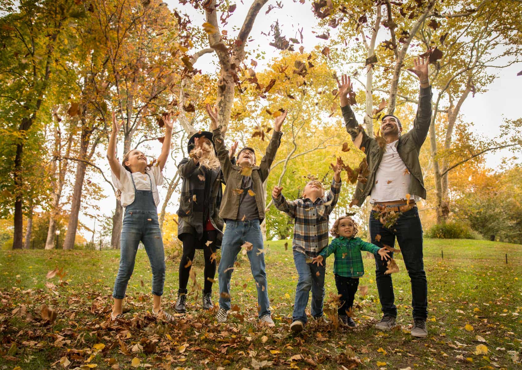 family playing in leaves