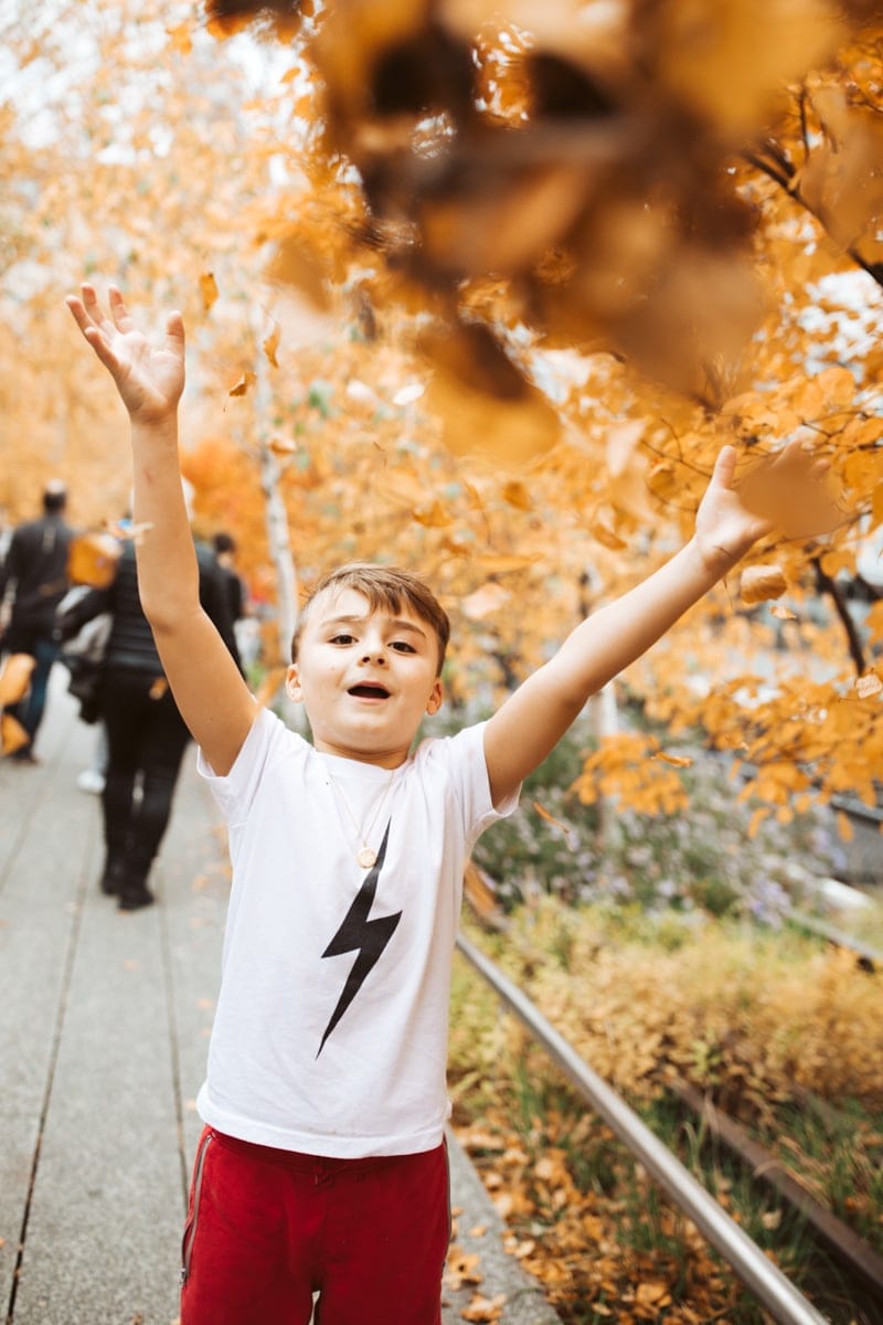 Boy Throwing Leaves NYC