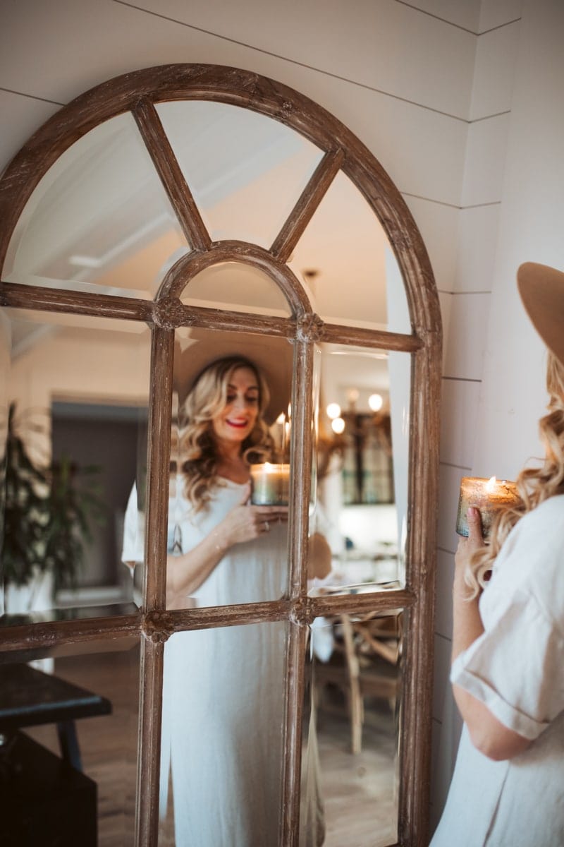 girl looking in mirror holding candle