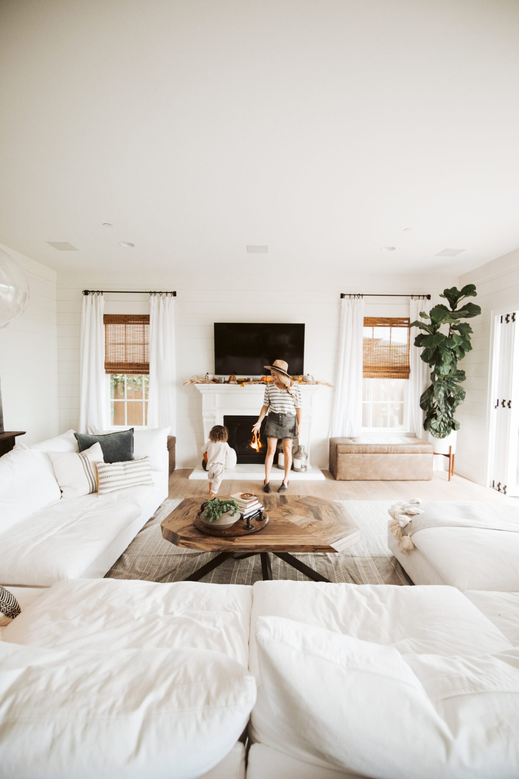 A mom and toddler playing in a white living room.