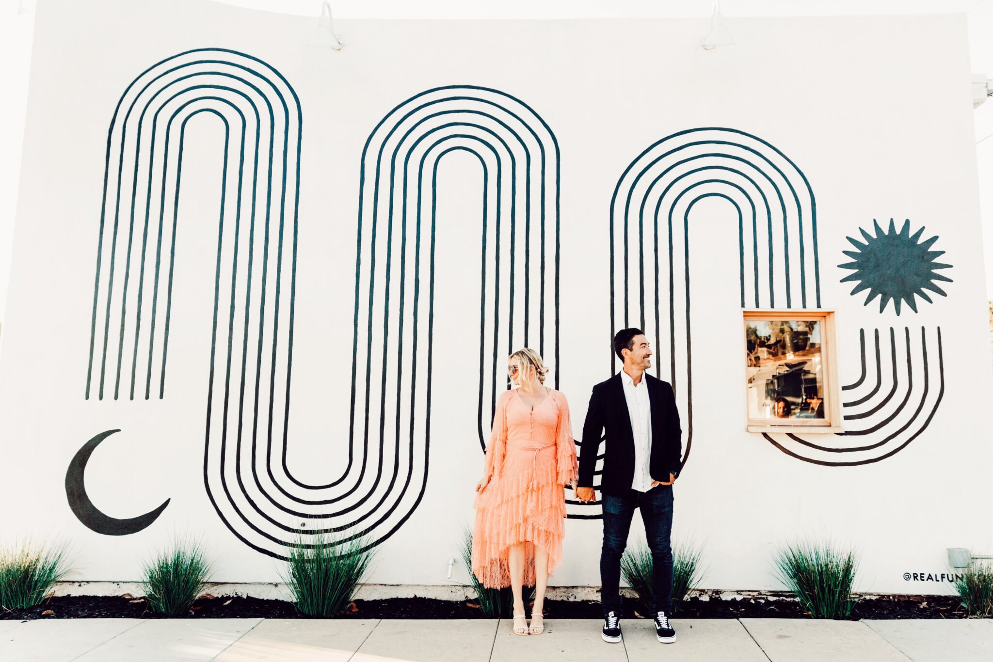 couple standing in front of mural 