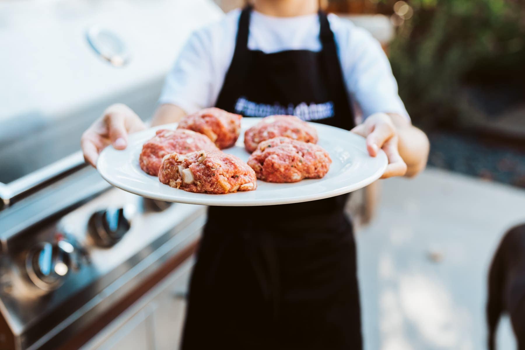 burger patties plates beside a grill