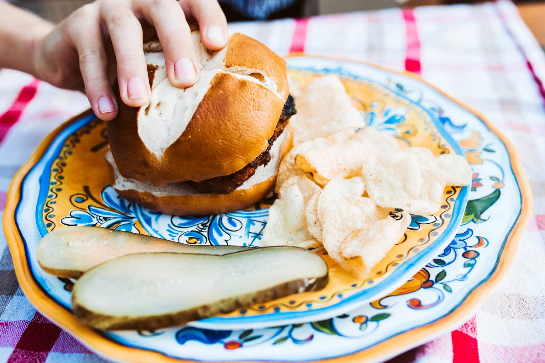 burger, chips, and pickles on a plate