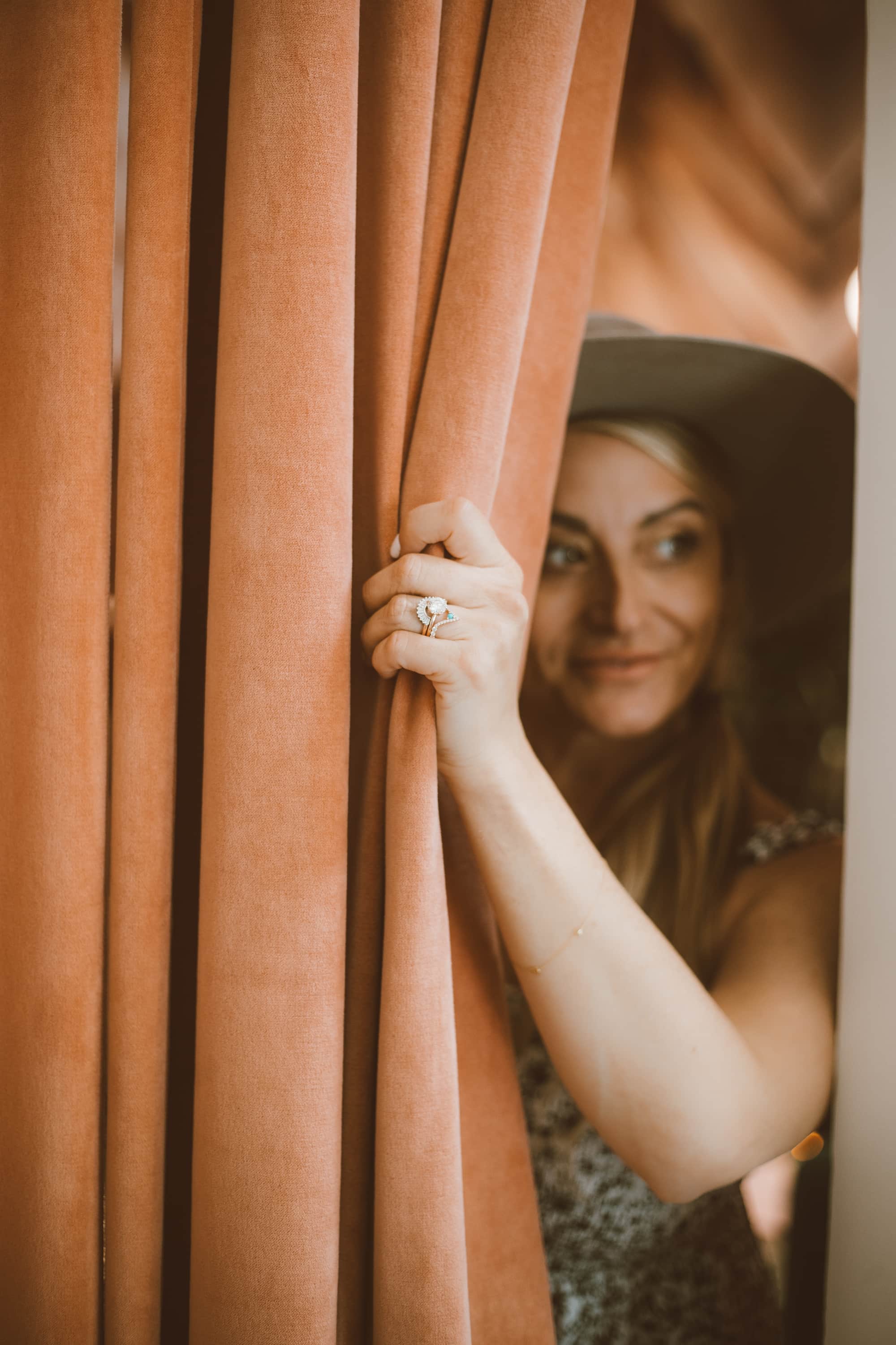 woman behind curtain with ring