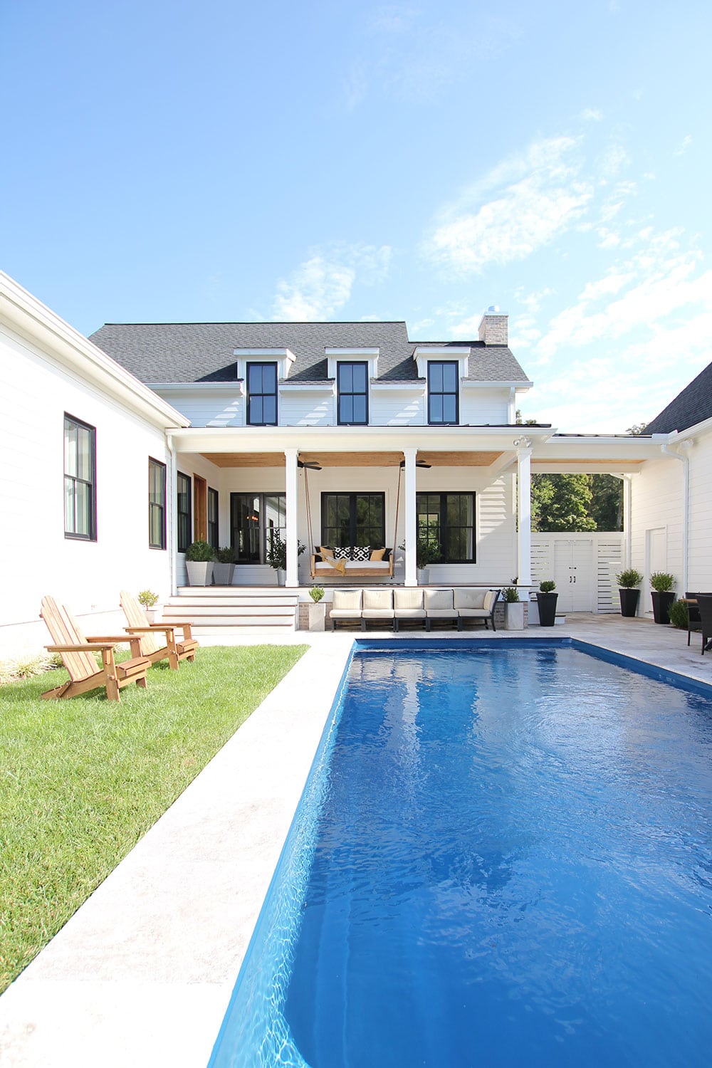 A modern farmhouse design with an outdoor pool.