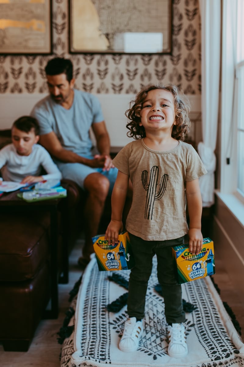 toddler holding crayons