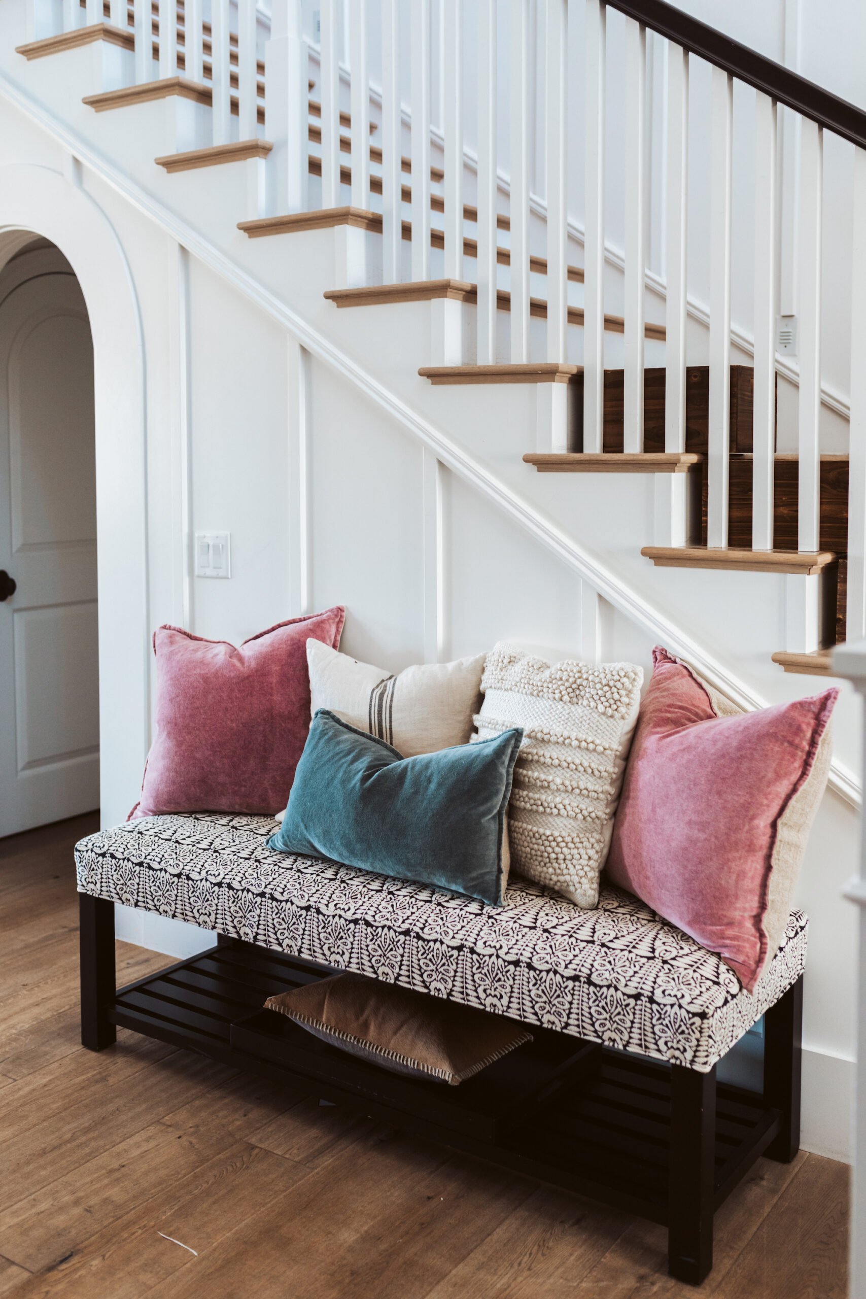 bench by staircase with pillows