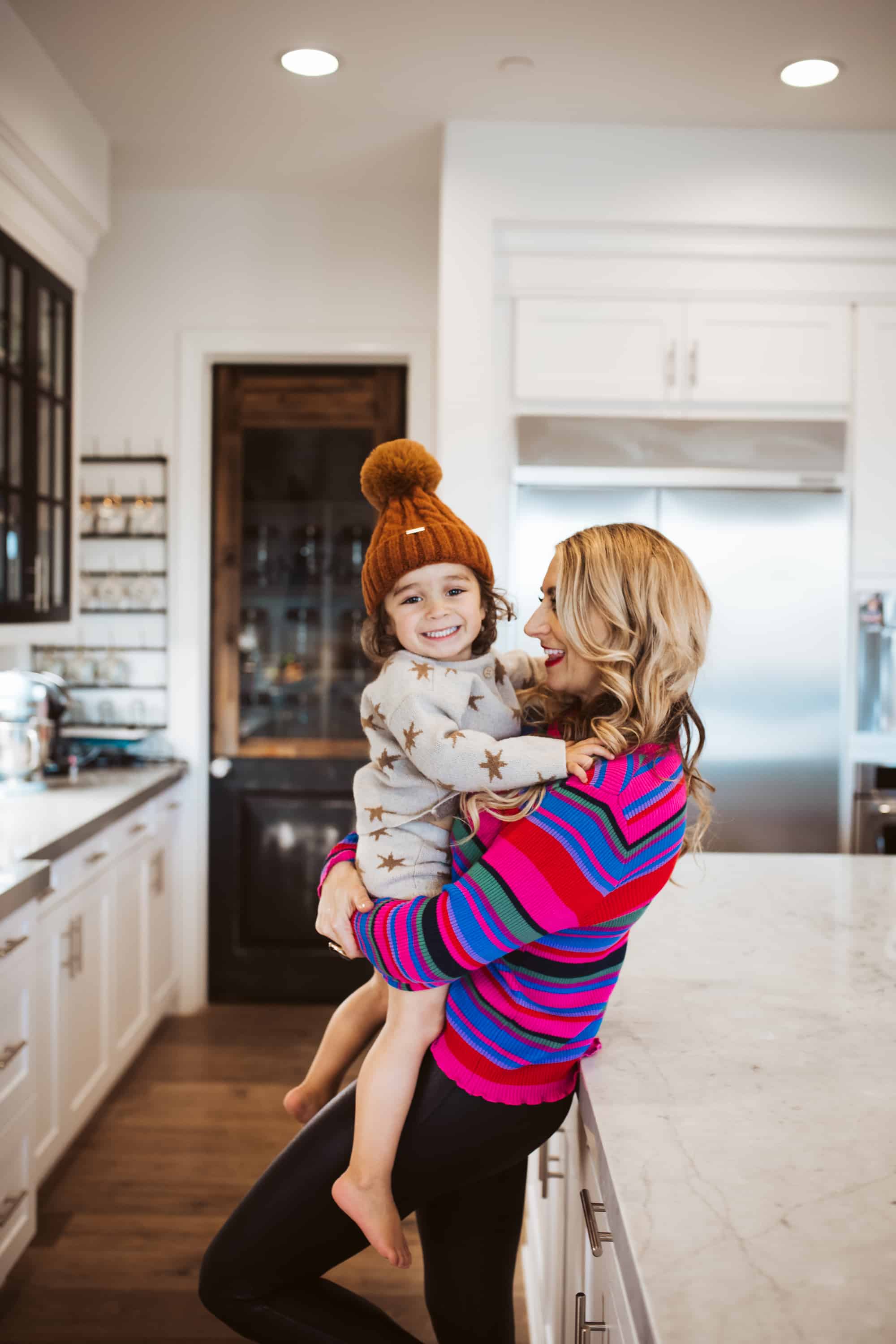 mom holding toddler in kitchen