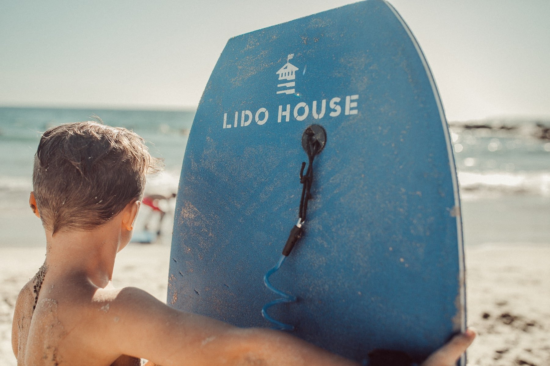 boy at beach with boogie board