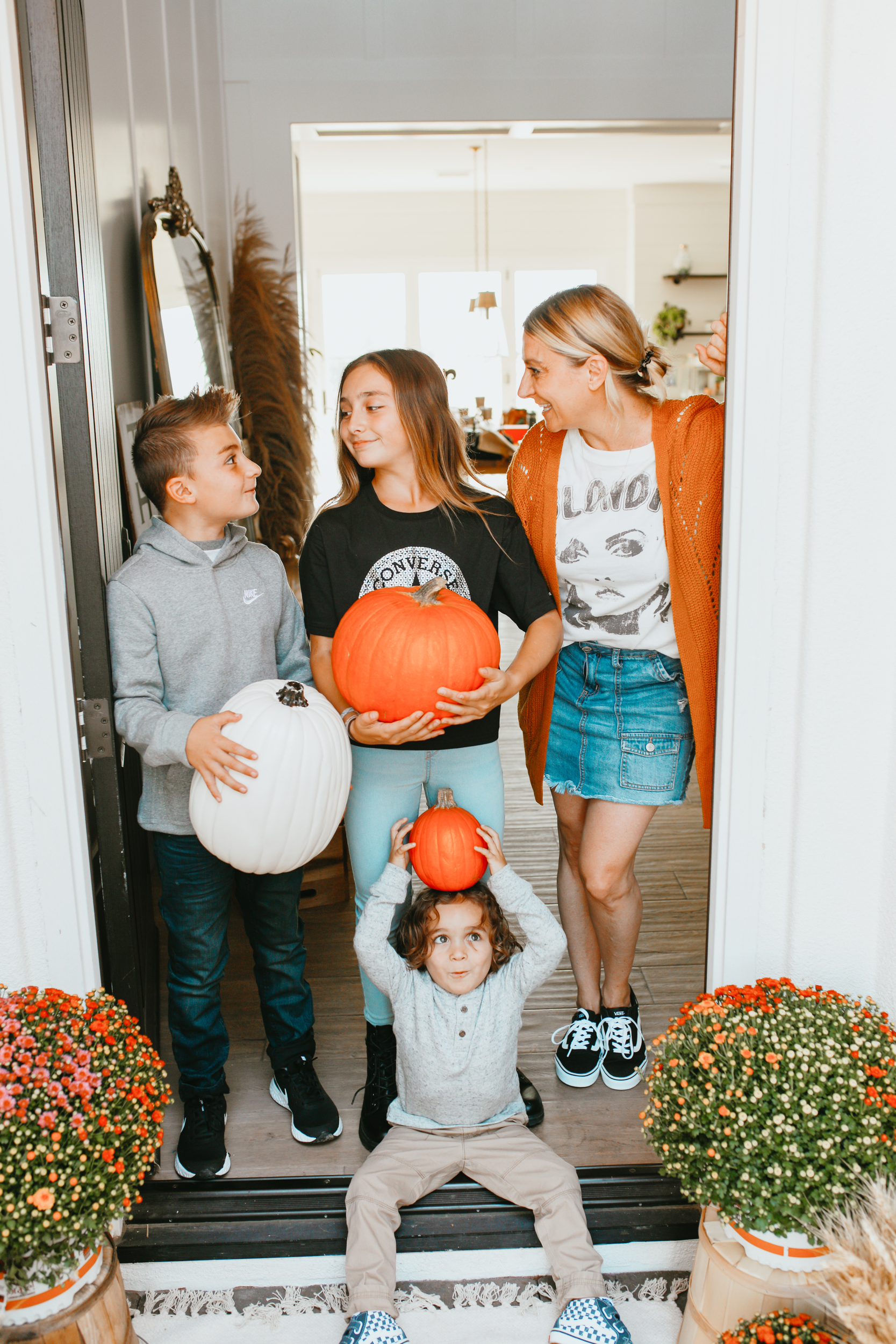 mom and kids holding pumpkins