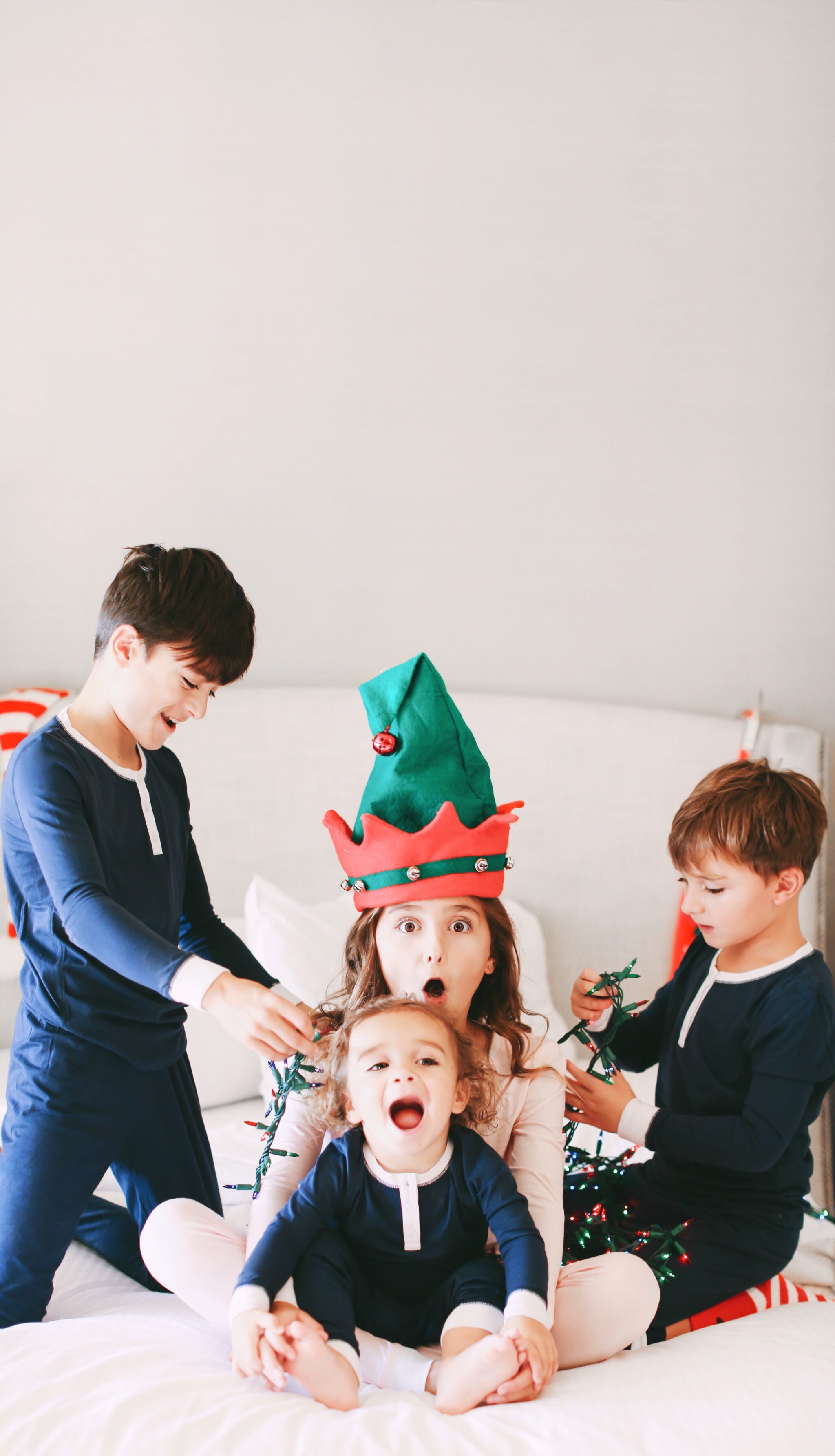 kids on bed in christmas pajamas