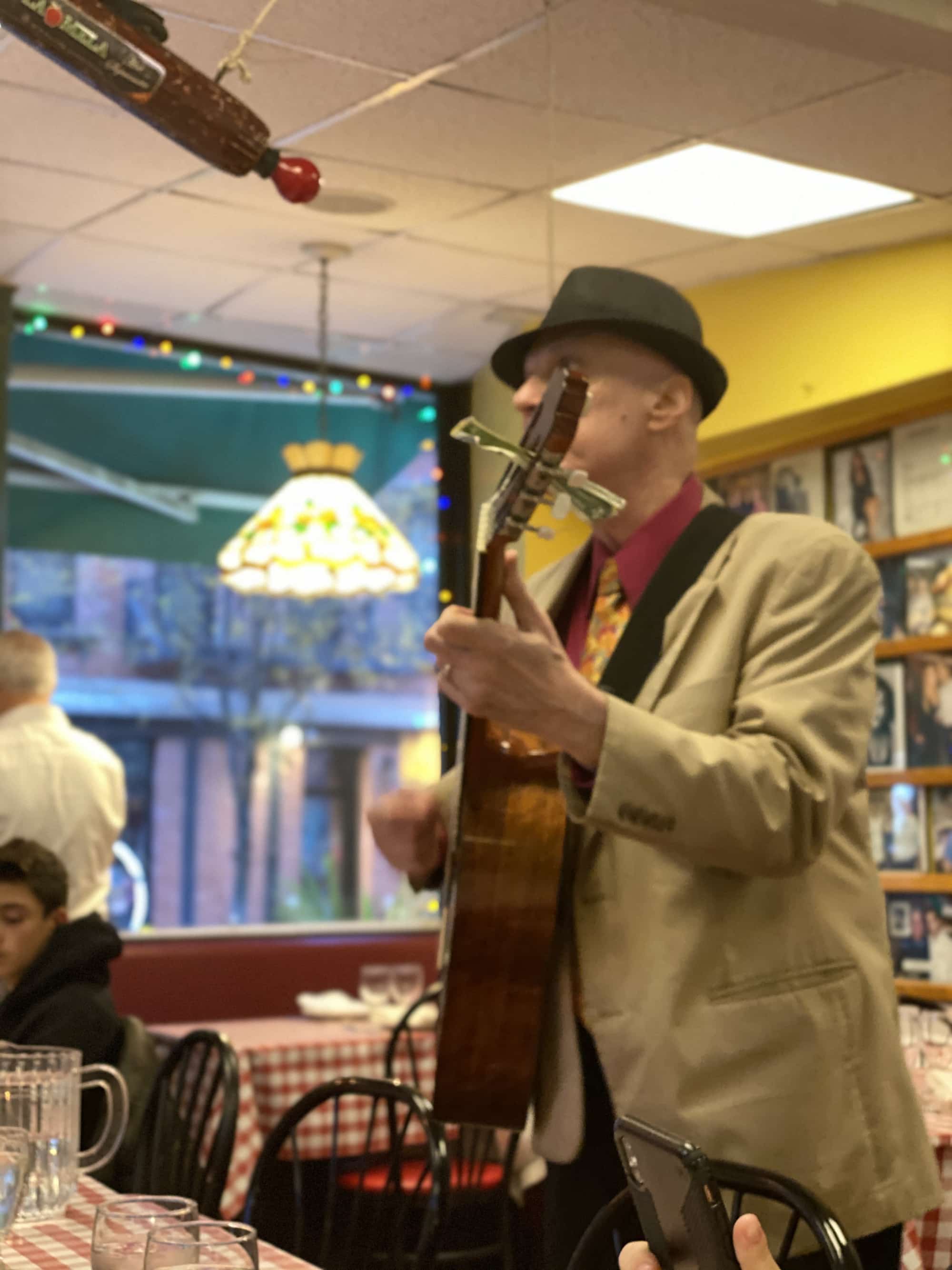 man playing the guitar in a restaurant