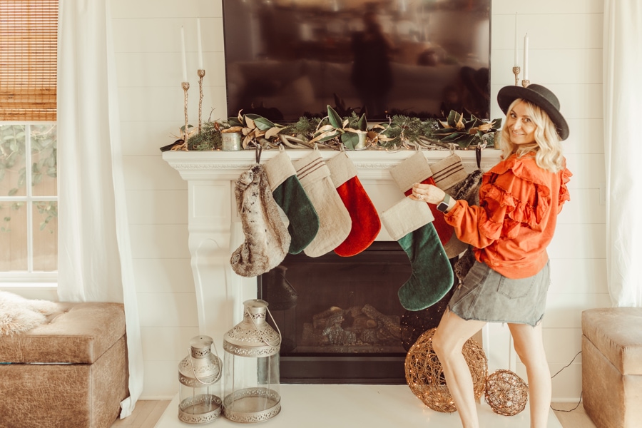 woman hanging stockings by fireplace