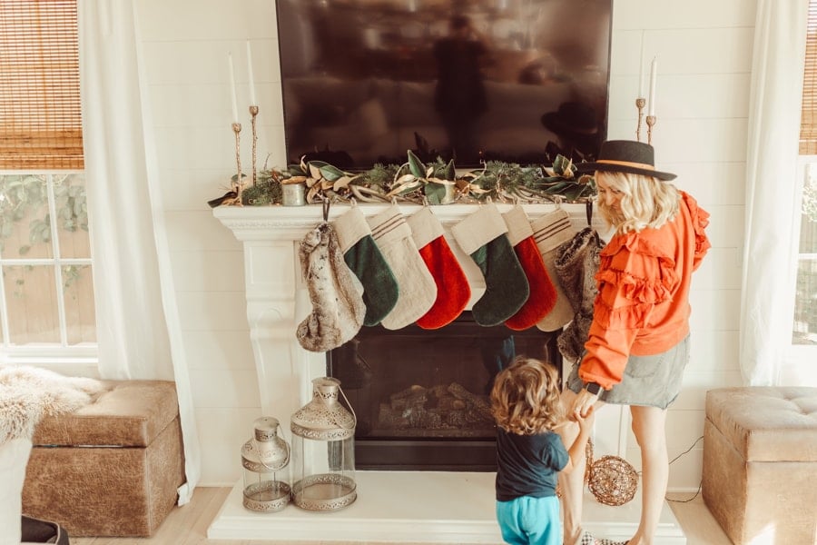 mother and son hanging christmas stockings