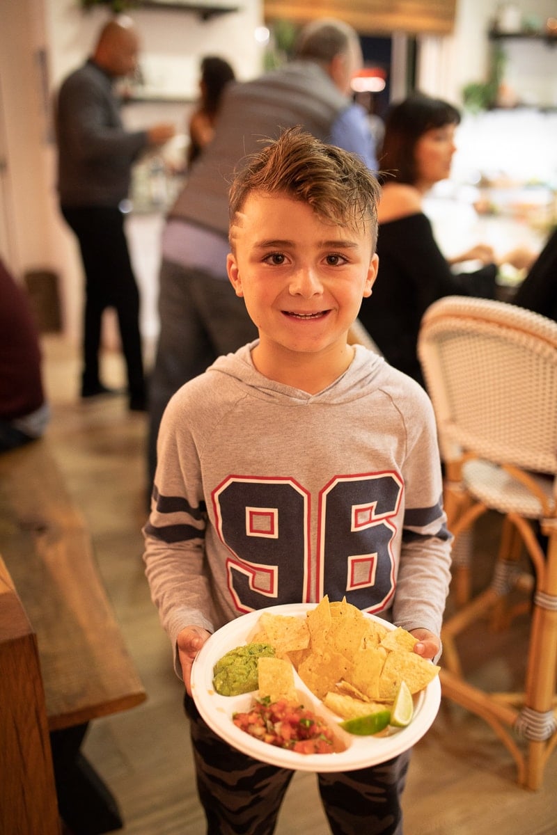 kid with plate of chips and guacamole