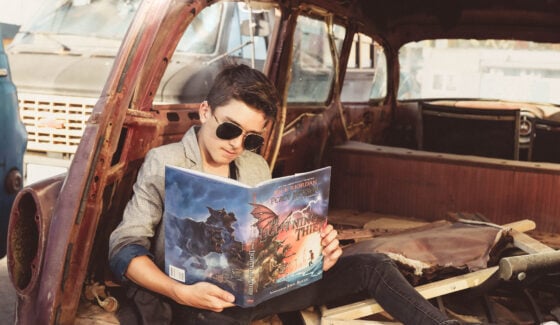 boy reading in old car