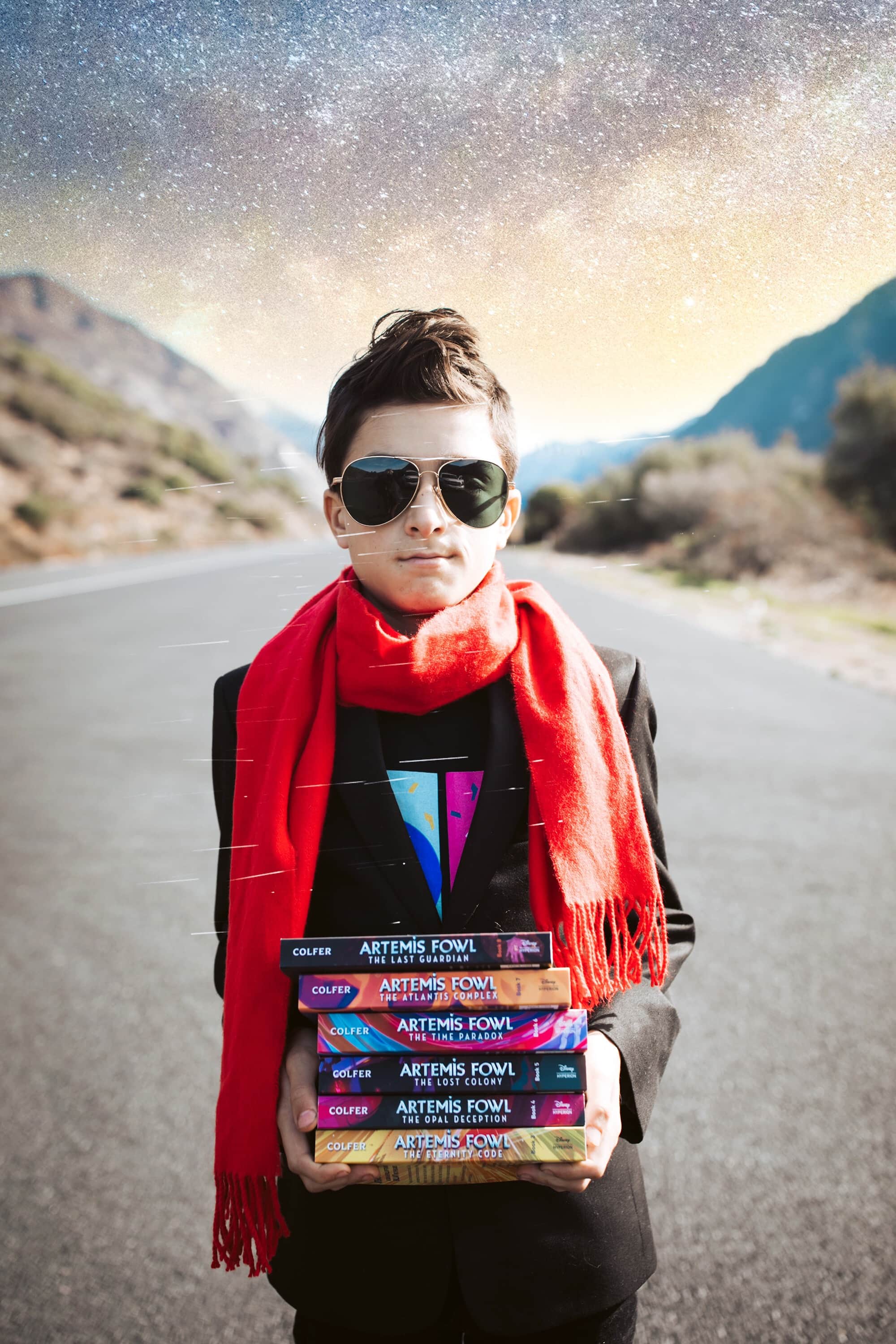 boy holding a stack of books