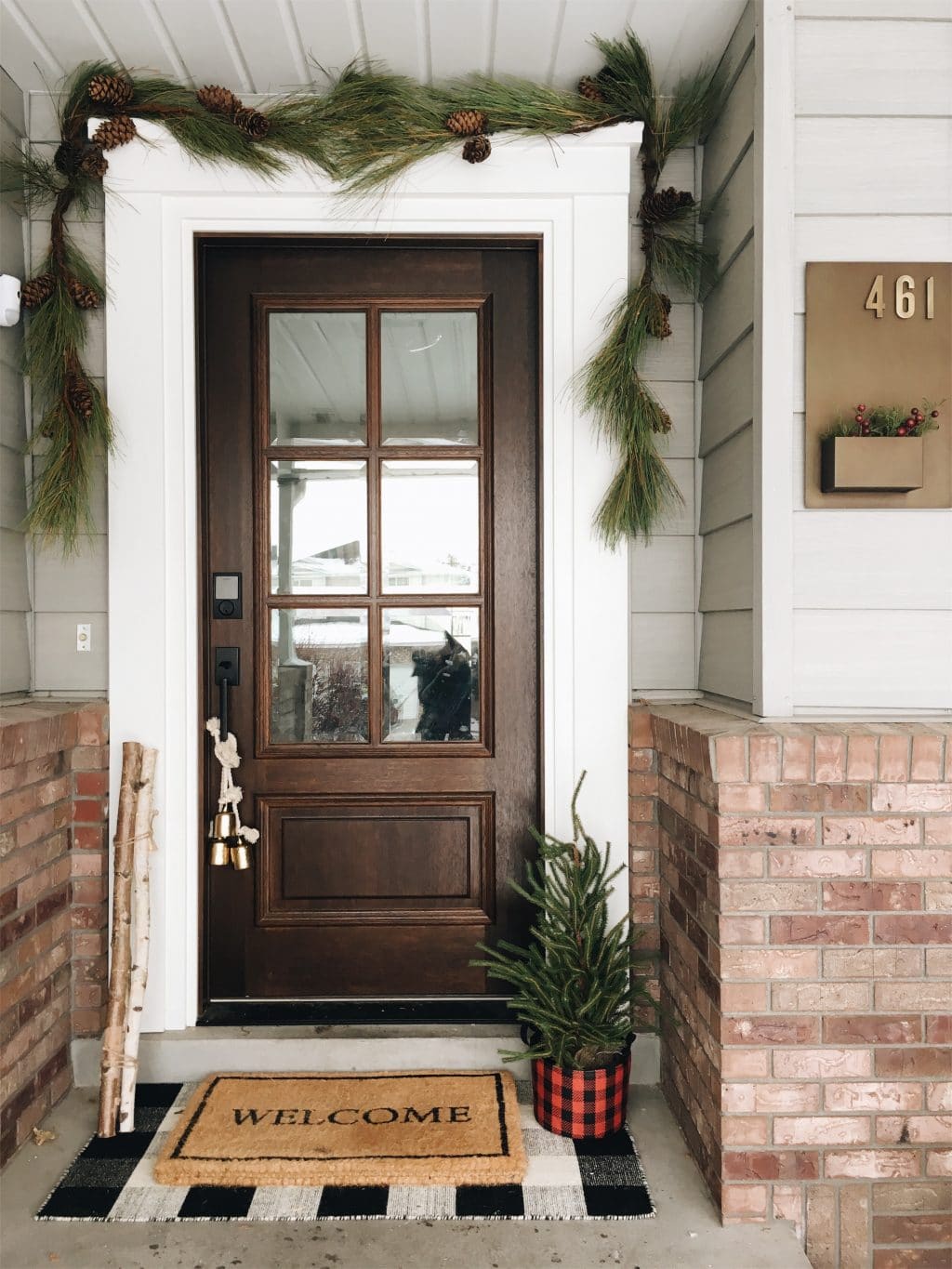 big brown front door with garland