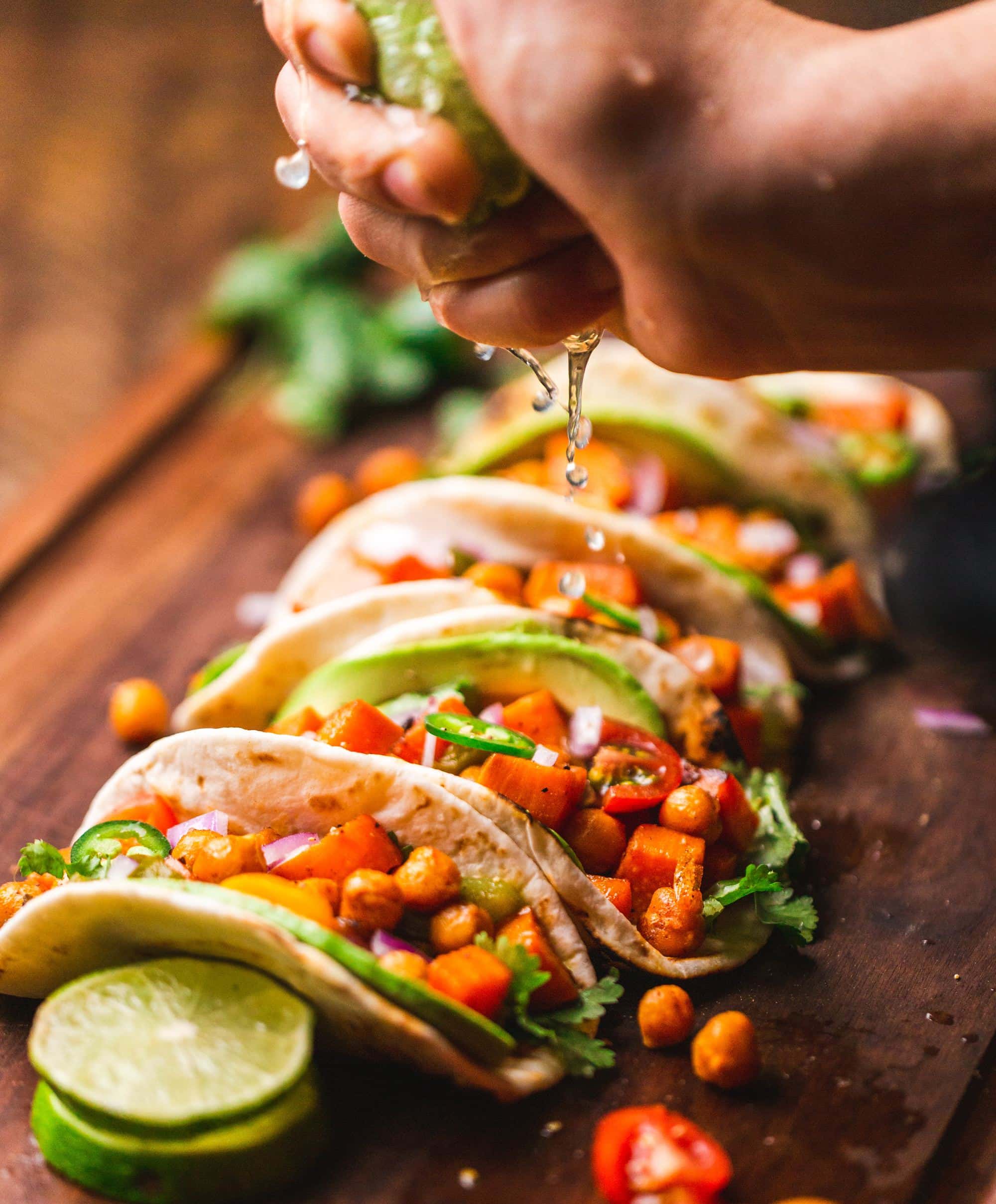 lime being squeezed over tacos