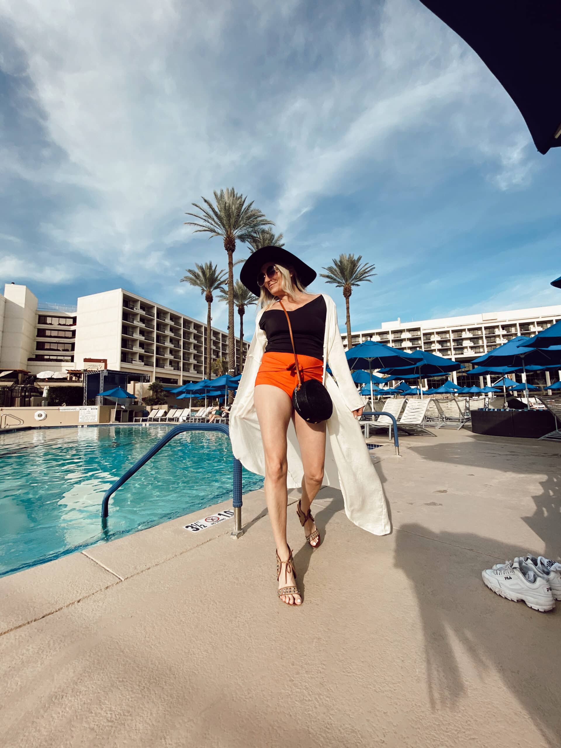 woman walking by pool in swimwear