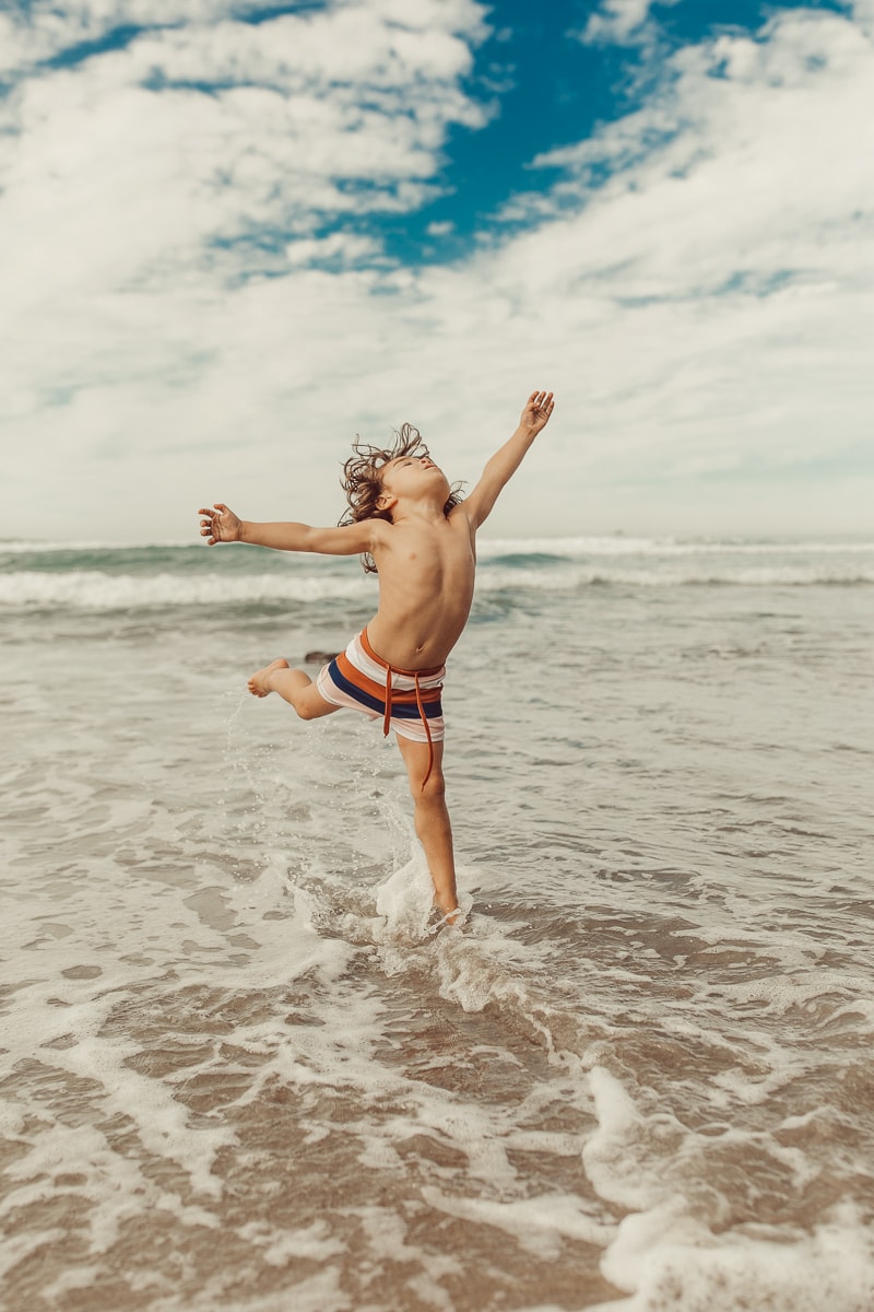 child dancing at the beach