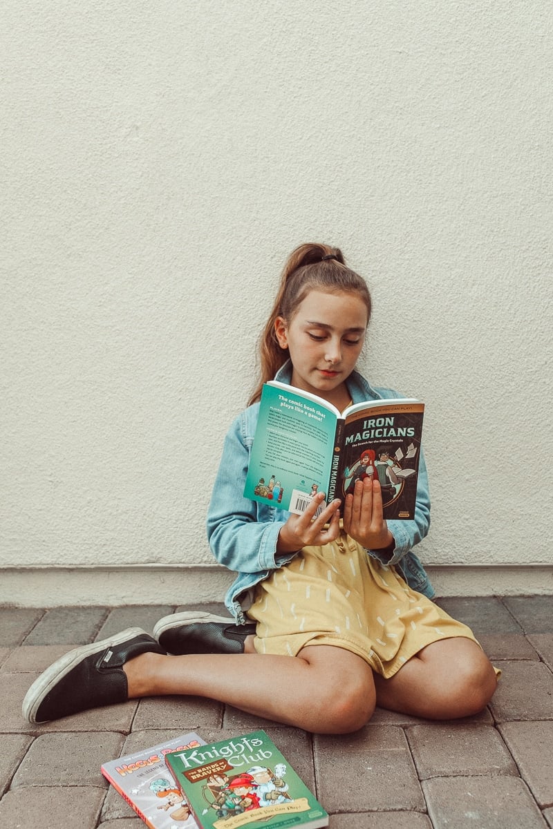 girl reading book outside