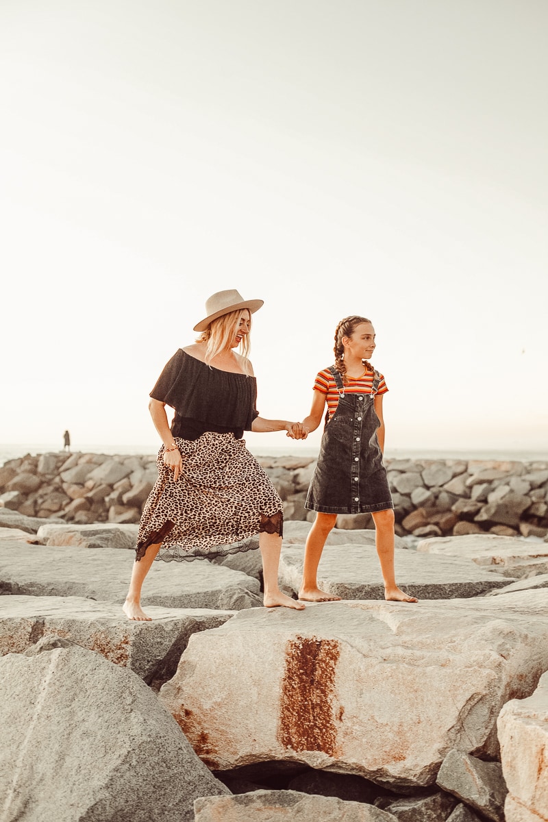 mother and daughter walking on rocks