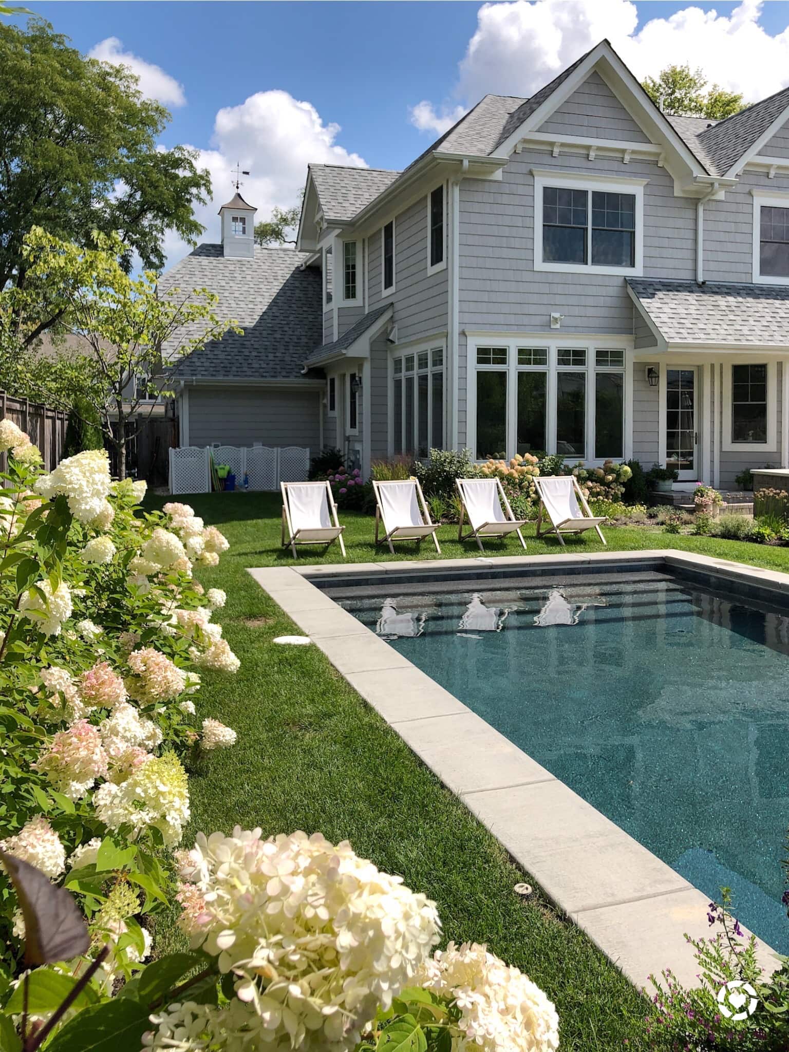 backyard with chairs, flowers and pool