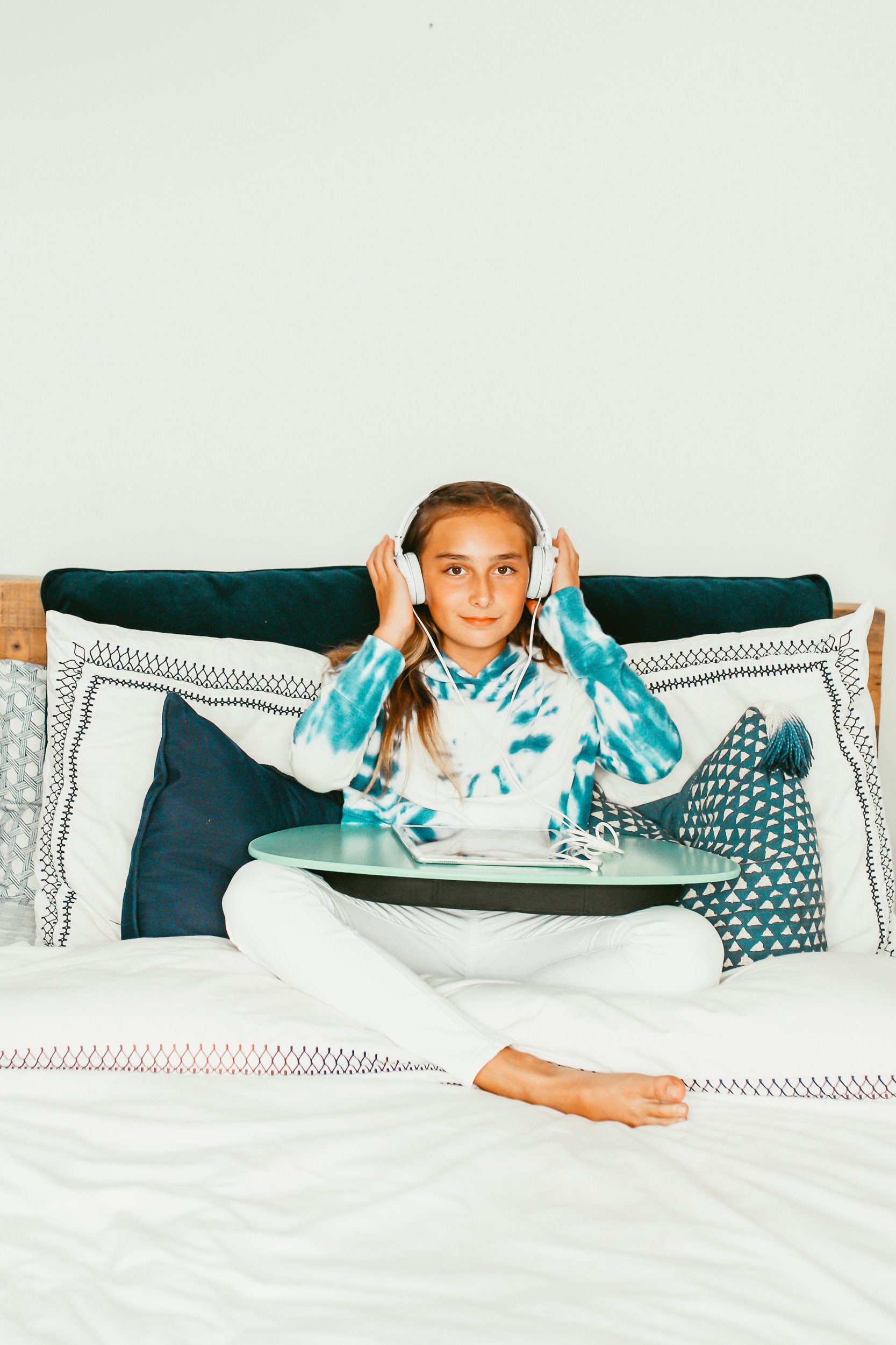 girl sitting in bed using ipad