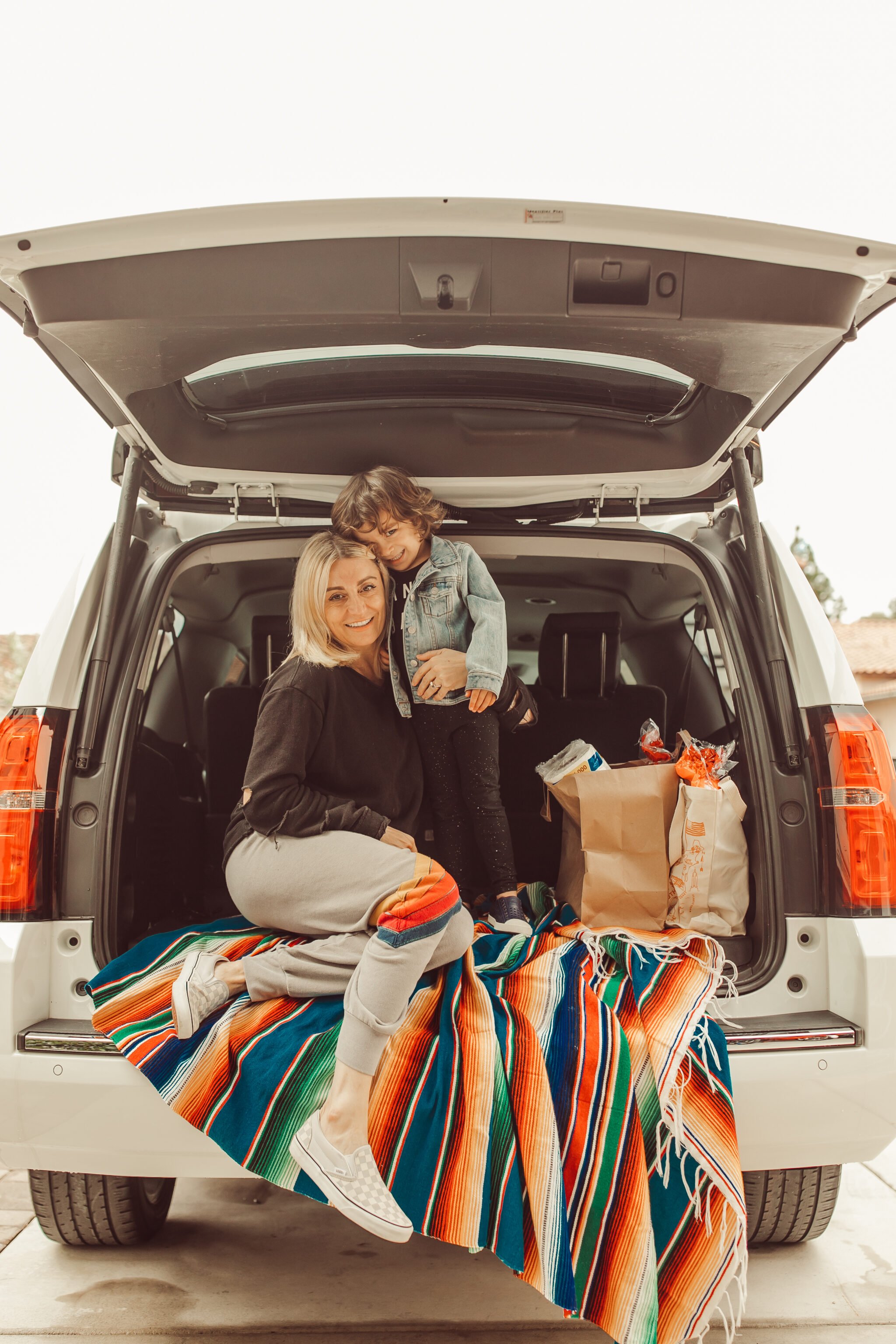 mom and kid with groceries in car