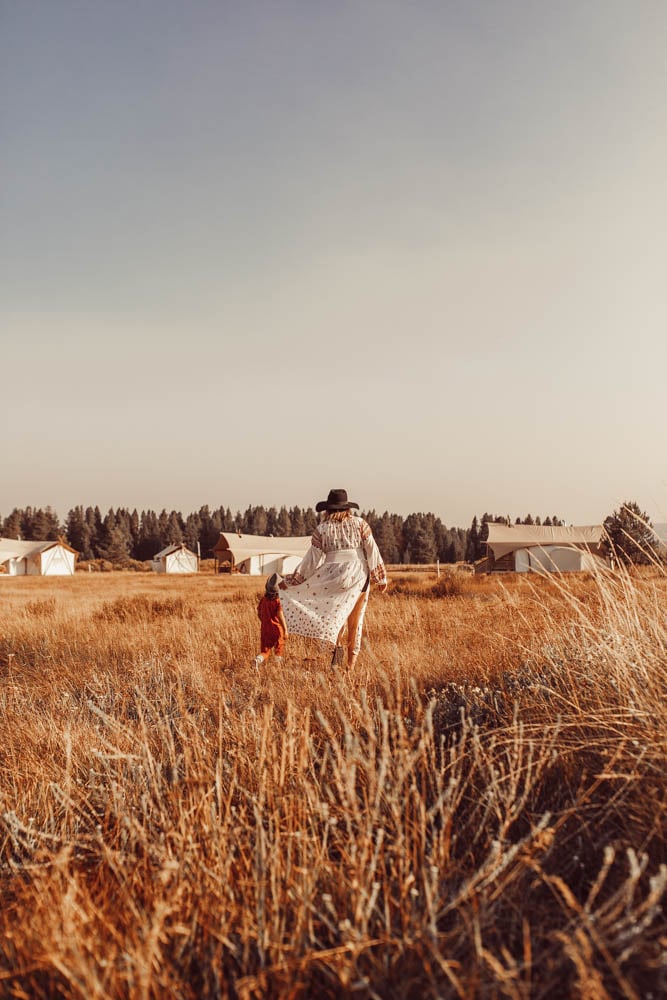 mom and child walking through field