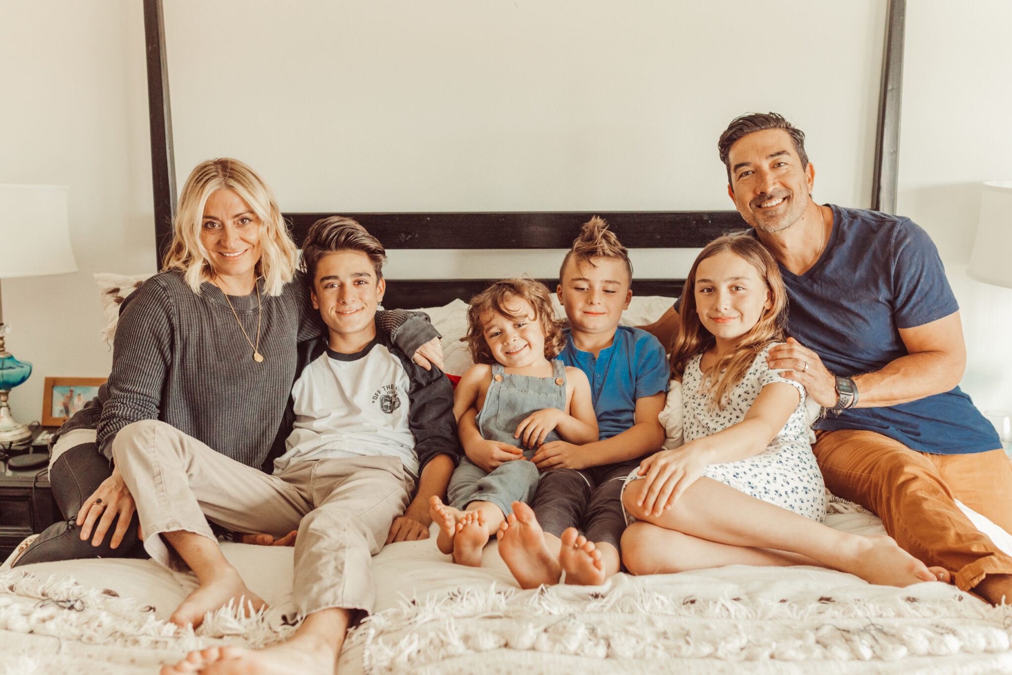 family sitting on bed