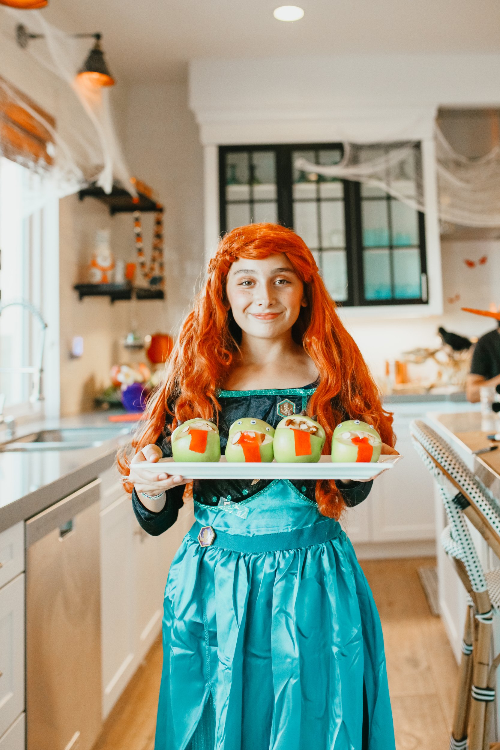 girl in halloween costume holding snacks