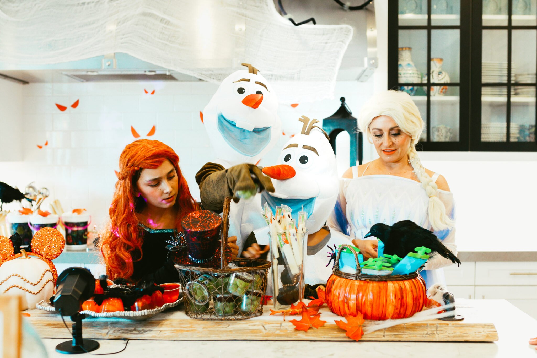 A family having a Frozen-themed Halloween party in the kitchen.