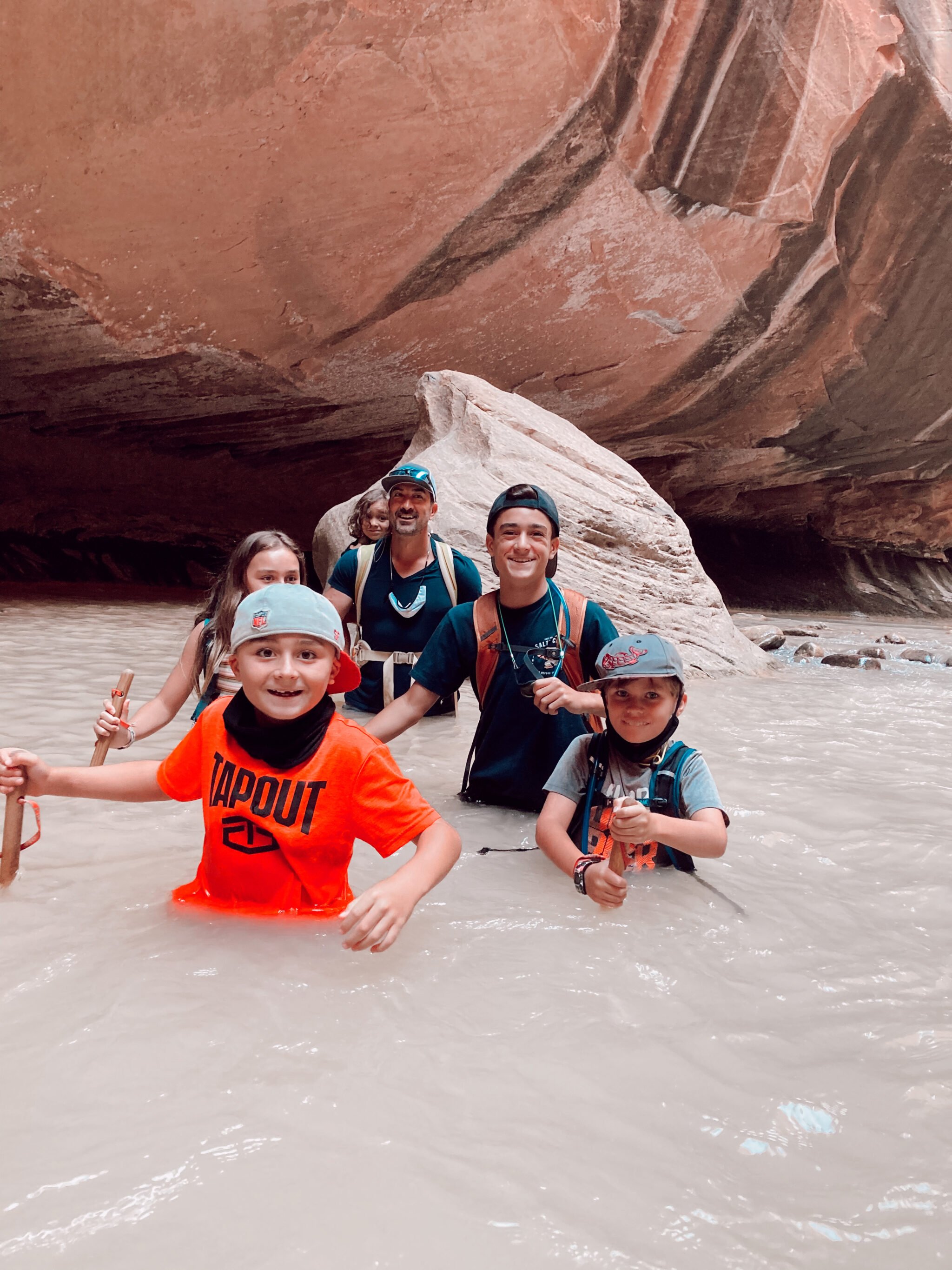 family hiking through river