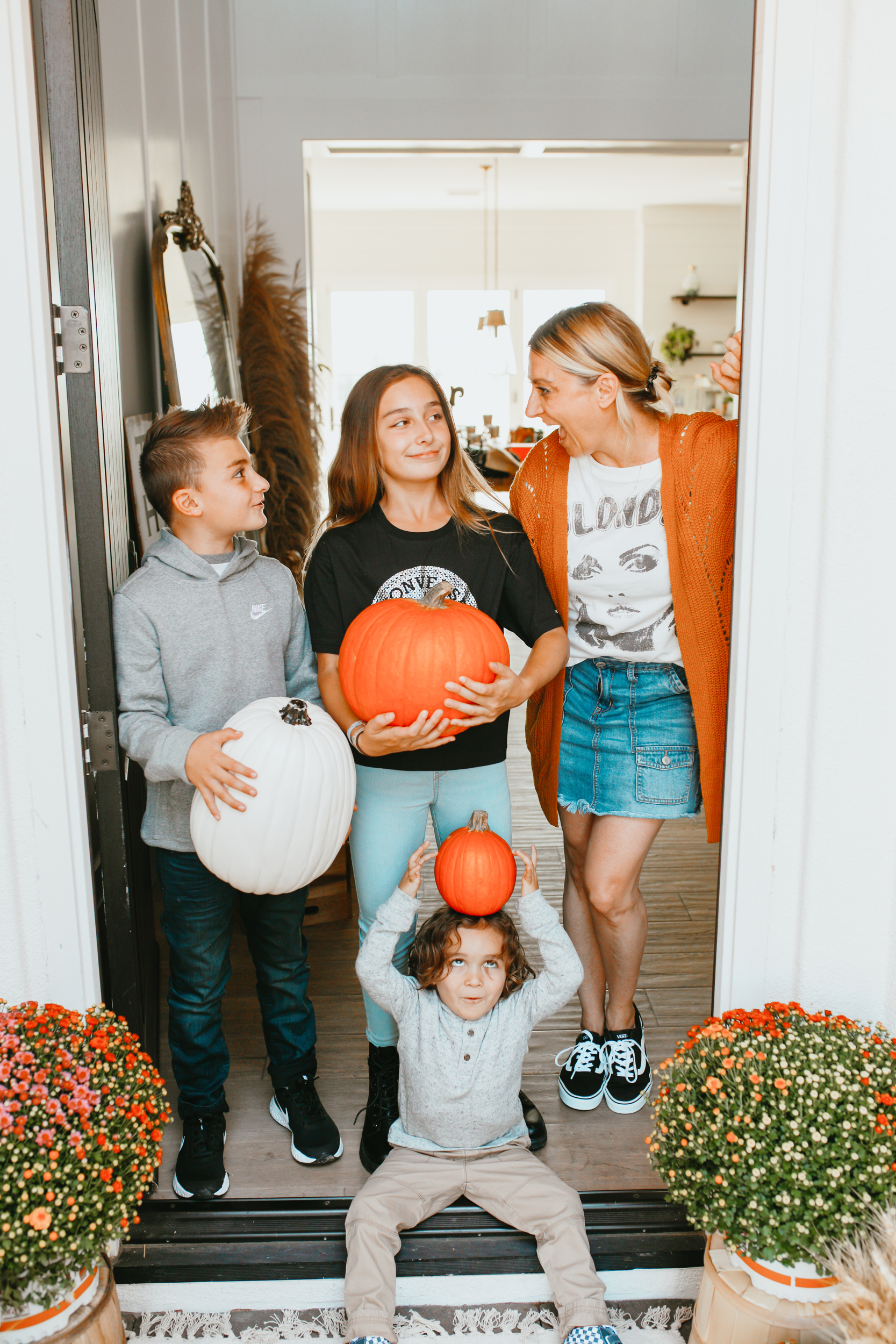 mom with kids all holding pumpkins